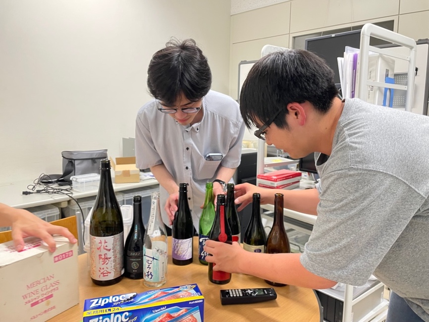 テーブルの上にある瓶と立ち上がる男性
中程度の精度で自動的に生成された説明